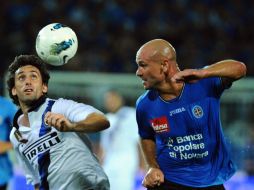 Milito (I), del Inter, pelea por el balón con Andrea Lisuzzo del Novara. AFP  /