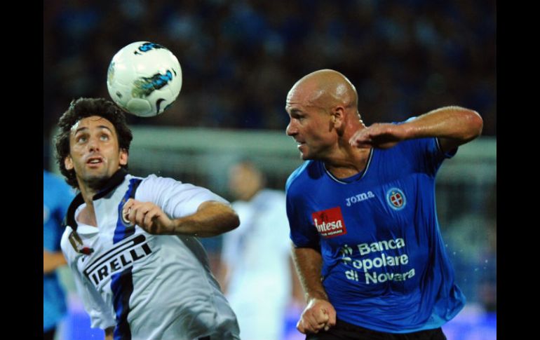 Milito (I), del Inter, pelea por el balón con Andrea Lisuzzo del Novara. AFP  /