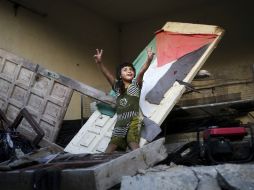 Una niña palestina hace signos de victoria durante una concentración en una vivienda destruida durante la guerra de Gaza. EFE  /