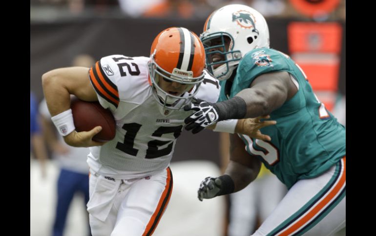 El defensa de los Delfines, Kendall Langford, (D) presiona a McCoy durante el juego. AP  /