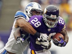 Adrian Peterson (frente) es tacleado por el vikingo DeAndre Levy. REUTERS  /