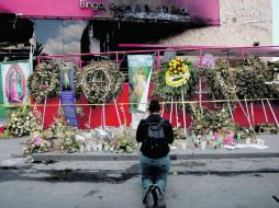 Una mujer reza frente a la fachada de la casa de apuestas. EL UNIVERSAL  /