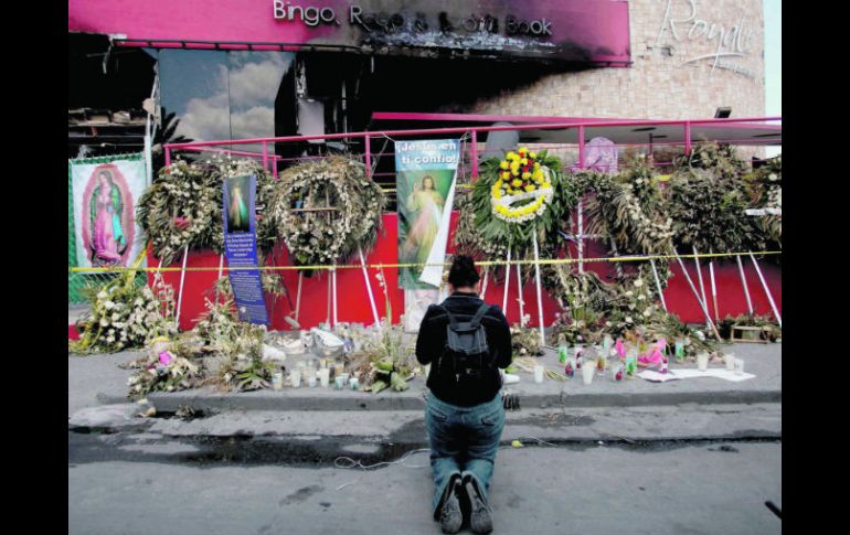 Una mujer reza frente a la fachada de la casa de apuestas. EL UNIVERSAL  /