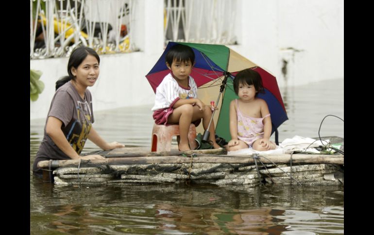 Una familia filipina afectada por el tifón Nesat en una embarcación improvisada en ''Malabón''. EFE  /