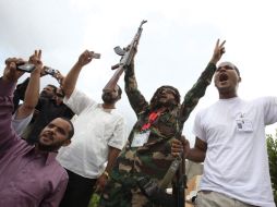 Unos hombres libios corean lemas durante el funeral de un combatiente rebelde que perdió la vida en Bani Walid, en Trípoli. EFE  /