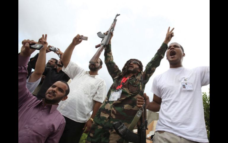 Unos hombres libios corean lemas durante el funeral de un combatiente rebelde que perdió la vida en Bani Walid, en Trípoli. EFE  /