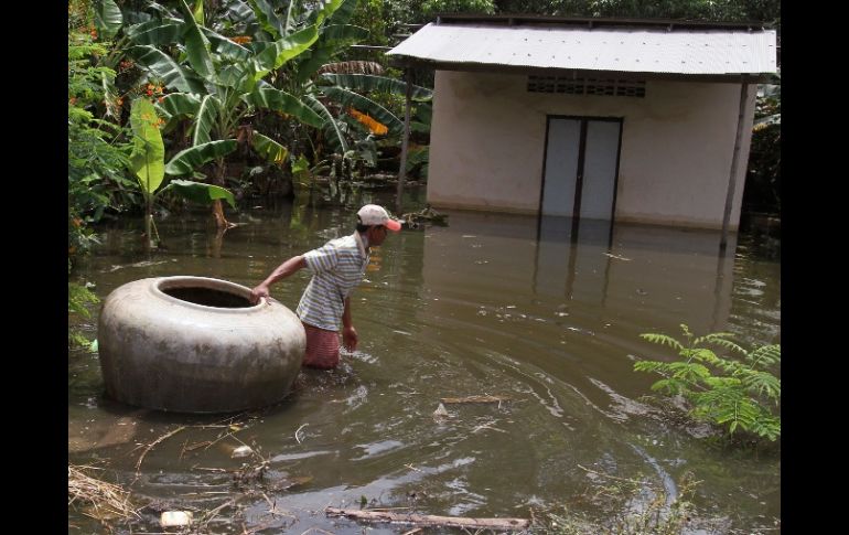 Un hombre jala un jarrón gigante enmedio de la inundación hoy, en las calles de Kandal, Camboya. REUTERS  /