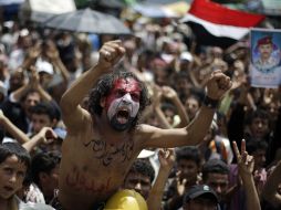 Un hombre se manifiesta hoy, con la leyenda 'firme en mi revolución hasta la victoria' en el pecho y la bandera yemení en el rostro. AP  /