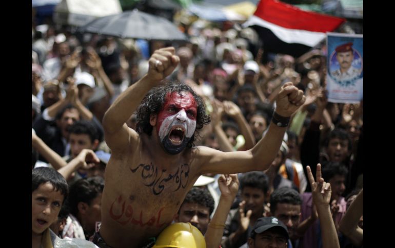 Un hombre se manifiesta hoy, con la leyenda 'firme en mi revolución hasta la victoria' en el pecho y la bandera yemení en el rostro. AP  /