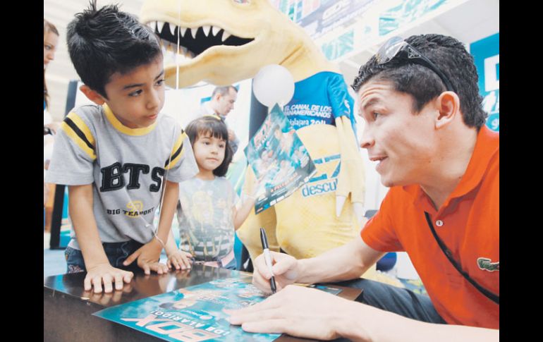 El púgil Ulises Solís firma un autógrafo a un niño durante la Feria Internacional Deportiva (Fidepo).  /