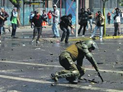 Manifestantes se enfrentan a pedradas con la Policía. Un oficial permanece en el piso, en Santiago de Chile. EFE  /