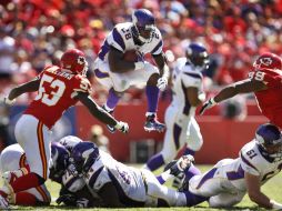 Adrian Peterson (28), Demorrio Williams (53) y Amon Gordon (99) durante la primera parte del encuentro entre Jefes y Vikingos. AP  /