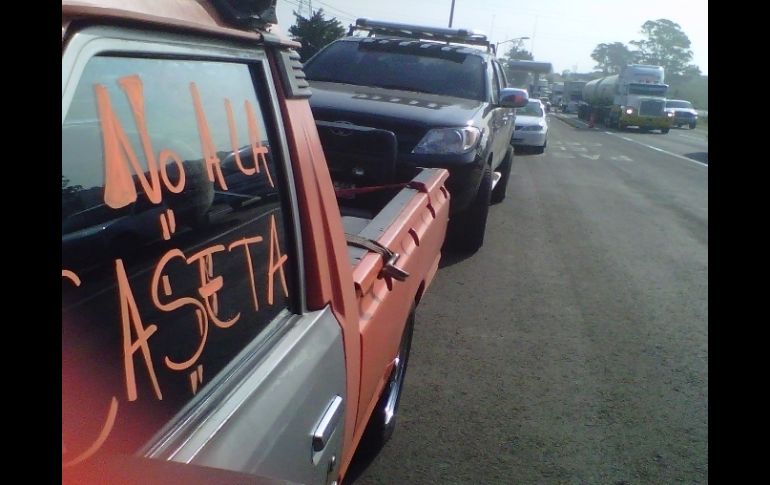 Estacionan vehículos en la lateral con consignas contra la caseta de cobro.  /