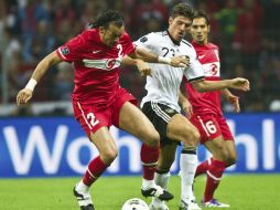 El jugador alemán Mario Gomez (c) disputa la pelota con el turco Servet Cetin (i). EFE  /