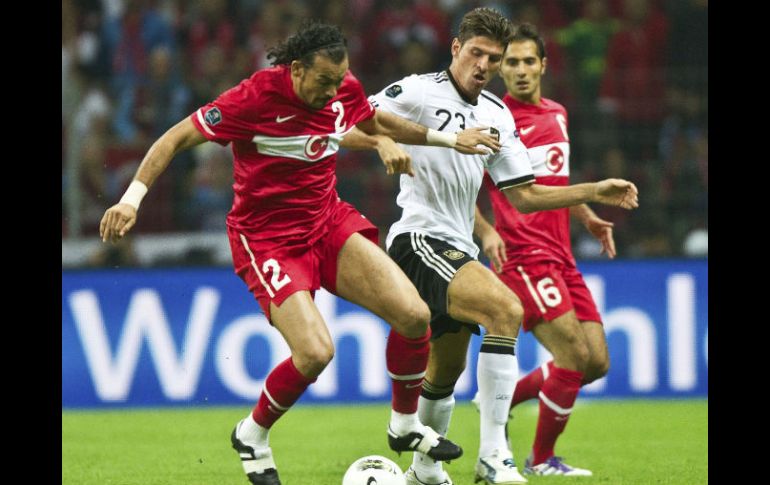 El jugador alemán Mario Gomez (c) disputa la pelota con el turco Servet Cetin (i). EFE  /