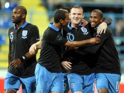 Los jugadores ingleses Ashley Young (D) y Wayne Rooney (C) celebran una anotación ante Montenegro. EFE  /