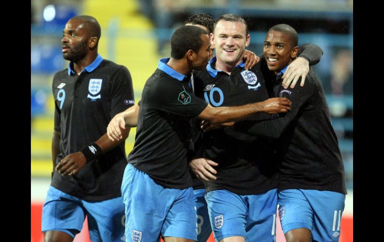 Los jugadores ingleses Ashley Young (D) y Wayne Rooney (C) celebran una anotación ante Montenegro. EFE  /