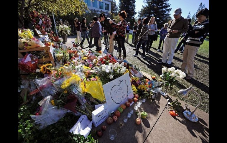 Seguidores de Jobs observan las flores y recuerdos dejados en su memoria en las oficinas centrales de Apple. AFP  /