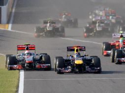 Polémica desde el arranque: Vettel y Button disputando la pista. AP  /