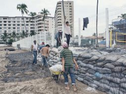 Trabajadores hacen una muralla con costales de arena para evitar daños ante el inminente arribo de ''Jova''. ESPECIAL  /