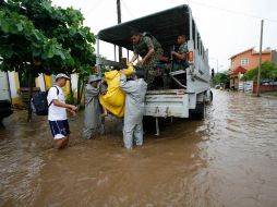 Soldados evacuan hoy a habitantes de una zona inundada en Villa de Coral, Colima. AP  /