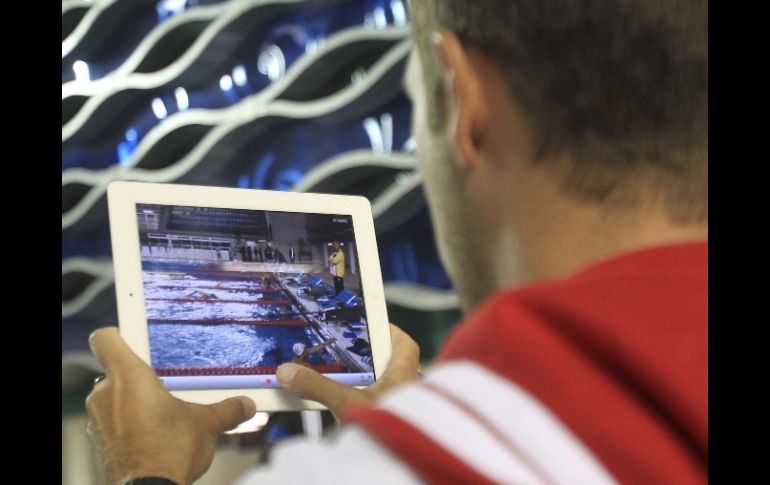 Un miembro de la delegación canadiense graba con un iPad la práctica de natación durante los ensayos en Panamericanos. REUTERS  /