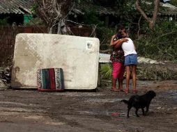 Mujeres se abrazan afuera de una vivienda afectada por el paso de ''Jova'' en La Huerta, Jalisco.  /