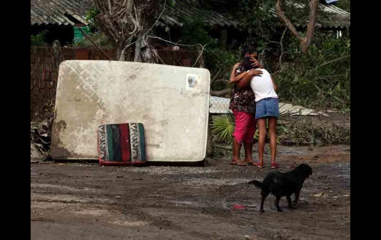 Mujeres se abrazan afuera de una vivienda afectada por el paso de ''Jova'' en La Huerta, Jalisco.  /