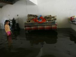 Iris Villa observa flotar sus pertenencias en su casa en El Chavarín, Colima. AP  /