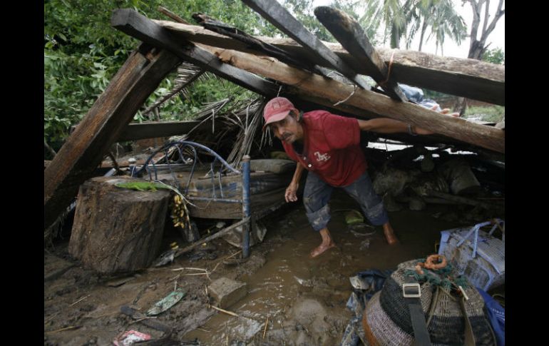 Guaquin Castellano entra a su casa destruida en El Chavarín, en Colima. AP  /