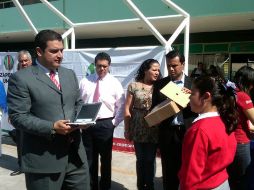 El alcalde de Zapopan, Héctor Vielma, hace entrega de una computadora a una estudiante.  /