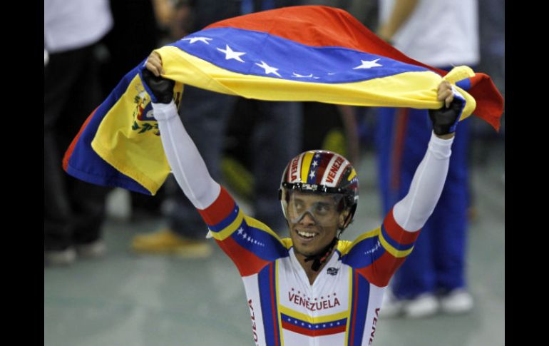 César Marcano, parte del equipo, celebra agitando una bandera de su país después de ganar. AFP  /