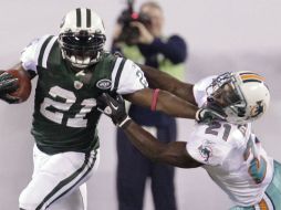 El corredor de los Jets, LaDainian Tomlinson, esquiva a Vontae Davis, de los Delfines,durante el Juego de Lunes por la Noche. AP  /