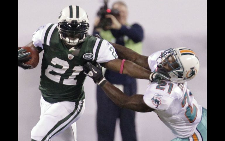 El corredor de los Jets, LaDainian Tomlinson, esquiva a Vontae Davis, de los Delfines,durante el Juego de Lunes por la Noche. AP  /