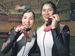 Daniela Gaxiola y Nancy Contreras muerden su medalla de bronce, tras finalizar la competencia. MEXSPORT  /