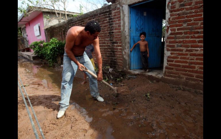 Uno de los habitantes realiza labores de limpieza fuera de su casa, afectada por el paso del huracán.  /