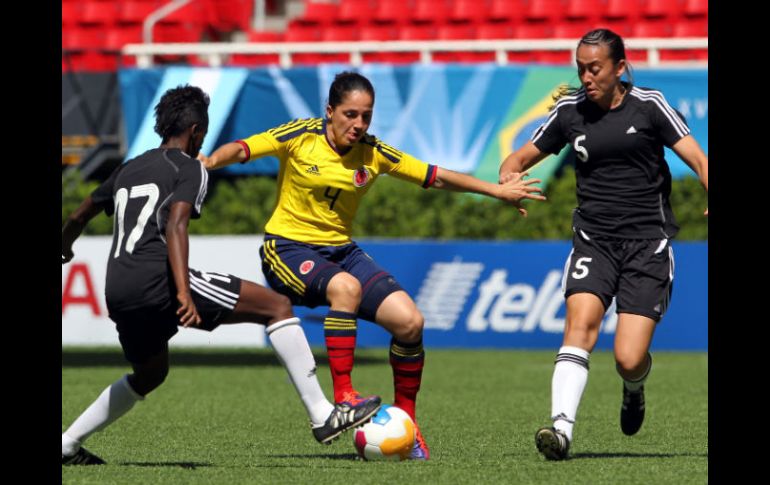 Las trinitenses Kennya Cordner (i) y Arin King (d) disputan el balón con la colombiana Diana Carolina Ospina. EFE  /