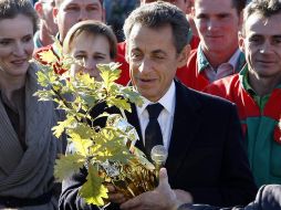 El presidente francés, Nicolás Sarkozy, recibe un árbol como regalo por el nacimiento de su hija. REUTERS  /