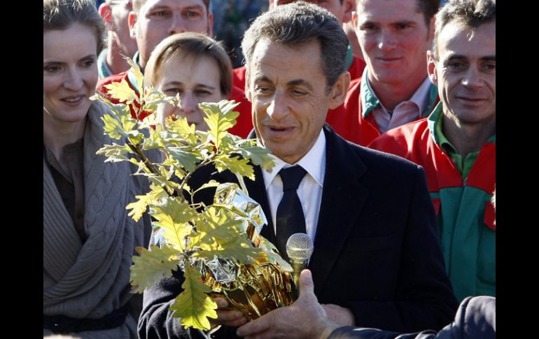 El presidente francés, Nicolás Sarkozy, recibe un árbol como regalo por el nacimiento de su hija. REUTERS  /