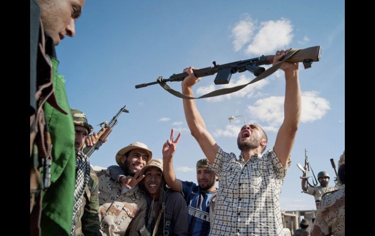 Rebeldes libios celebran en las calles tras la caída de Sirte y la muerte de Gadhafi. AP  /