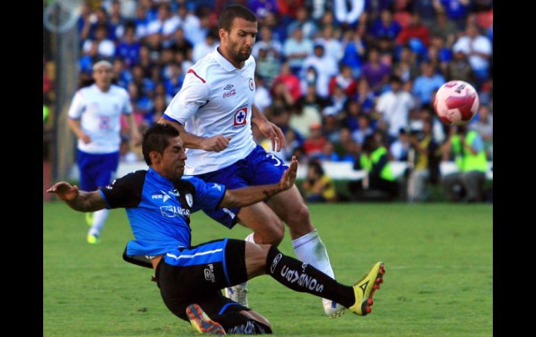 Manuel López Mondragon (I) de Querétaro aparta el balón del poder de Emanuel Villa de Cruz Azul. AFP  /