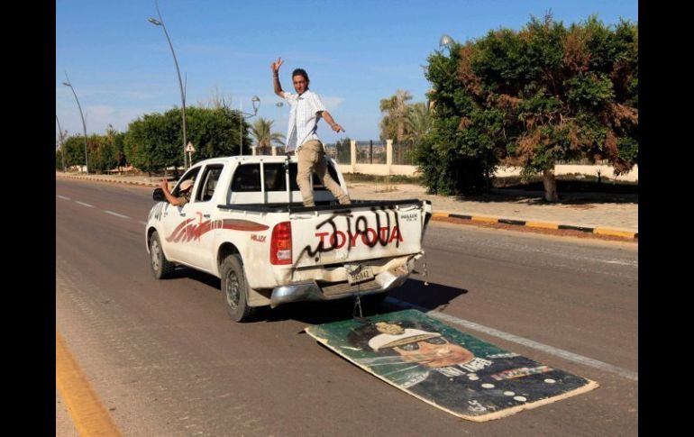 Un libio arrastra simbólicamente un retrato de Gadhafi en Sirte, en la parte posterior del transporte se lee: Alá es grande. REUTERS  /