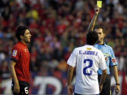 El centrocampista del Osasuna Nekounam, observa al árbitro José Luis González sacar la tarjeta amarilla al mexicano Efraín Juárez. EFE  /