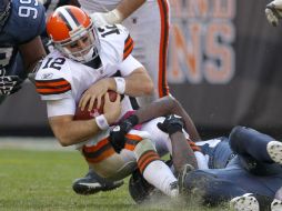 Colt McCoy (12) es saqueado por el defensa del los Halcones Marinos Chris Clemons. AP  /