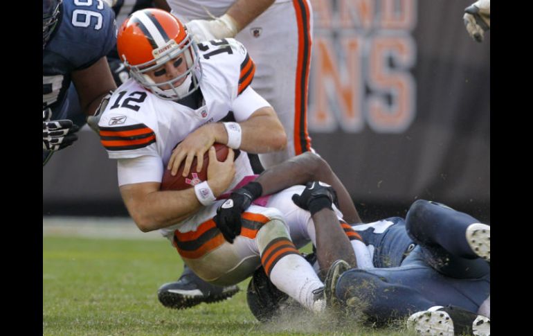 Colt McCoy (12) es saqueado por el defensa del los Halcones Marinos Chris Clemons. AP  /