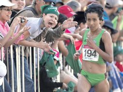 Madaí Pérez es animada por una mujer espectadora durante el recorrido del maratón femenil.  /