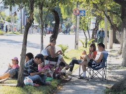 Previo al arranque de la competencia, una familia arma un ''picnic'' sobre una de las calles tapatías por las que pasó el maratón.  /