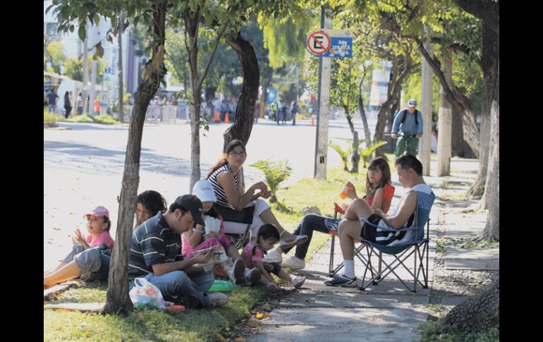 Previo al arranque de la competencia, una familia arma un ''picnic'' sobre una de las calles tapatías por las que pasó el maratón.  /