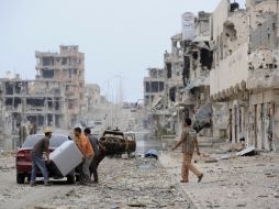 Ciudadanos de la ciudad de Sirte cargan sus pertenencias en un auto. El nuevo gobierno tendrá la misión de reunificar la nación. AFP  /