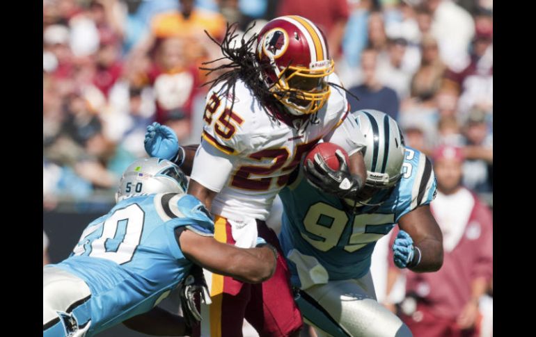 Tim Hightower (25) intenta huír de las 'garras' de las Panteras de Carolina durante su encuentro anterior. REUTERS  /